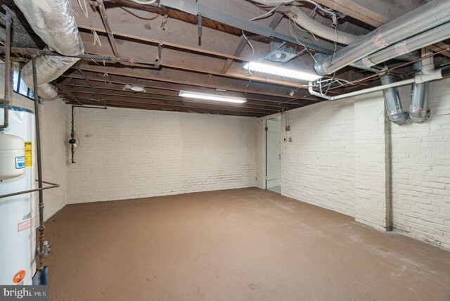unfinished basement featuring brick wall