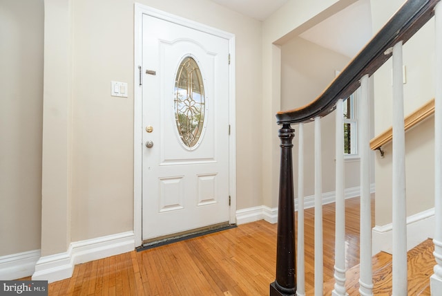entryway featuring baseboards, light wood-style flooring, and stairway
