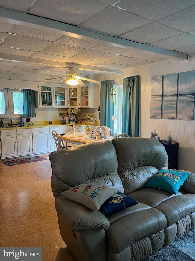 living area featuring wood walls and a ceiling fan