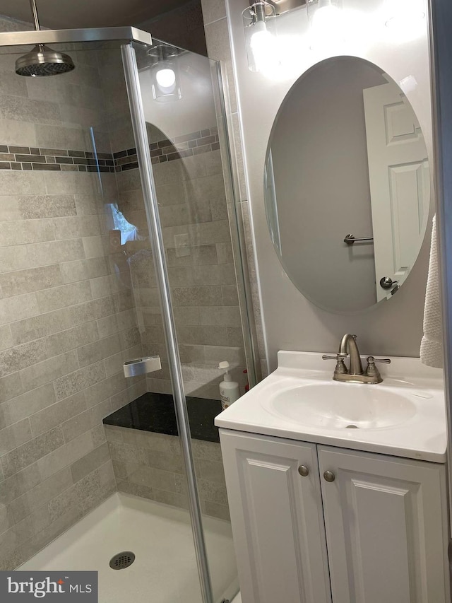 full bath with vanity and a shower stall