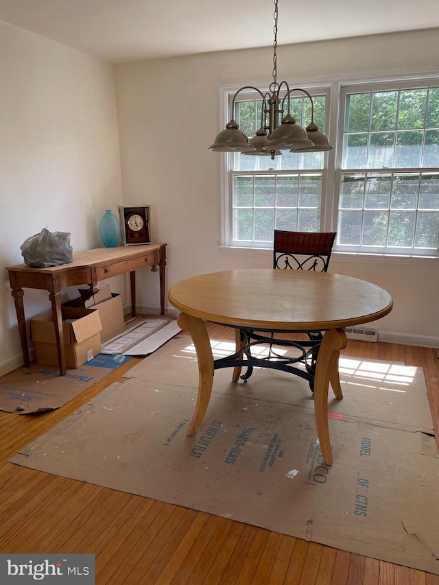 dining area with baseboards, a chandelier, and hardwood / wood-style floors