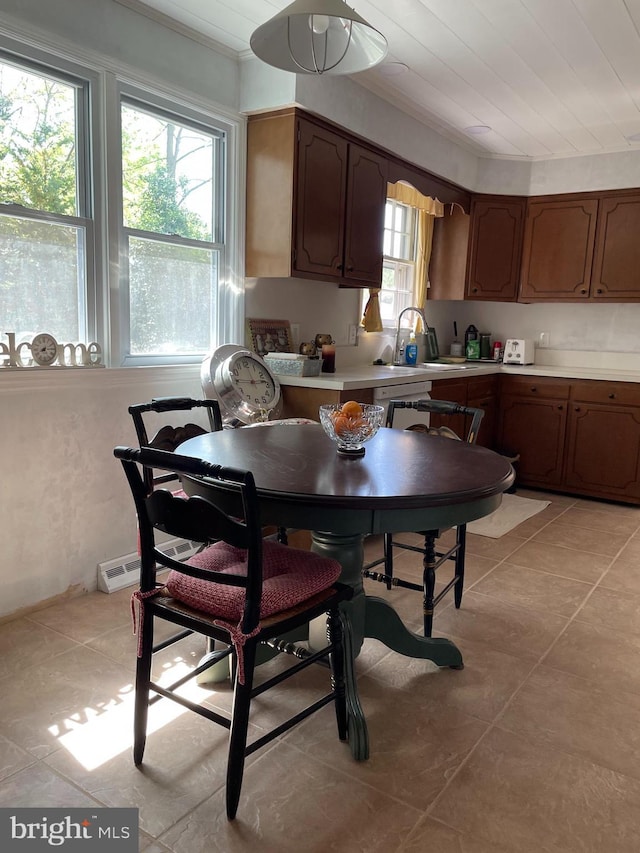 kitchen featuring a sink, light tile patterned floors, ornamental molding, and light countertops