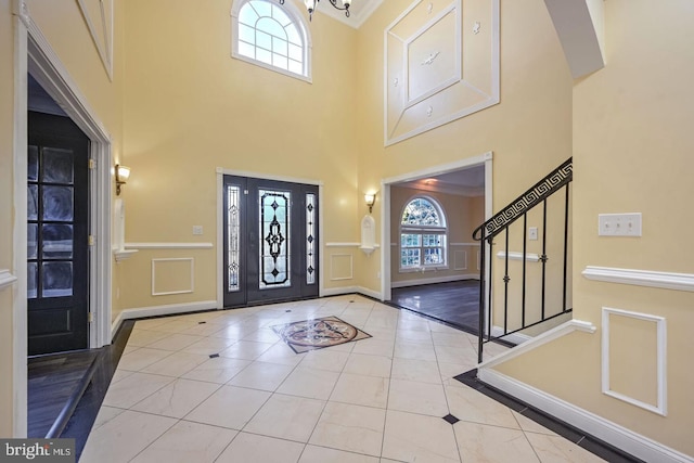 6411 L St, Capitol Heights, MD 20743 - entryway featuring inlaid floor details, a towering ceiling, baseboards, tile patterned flooring, and stairs