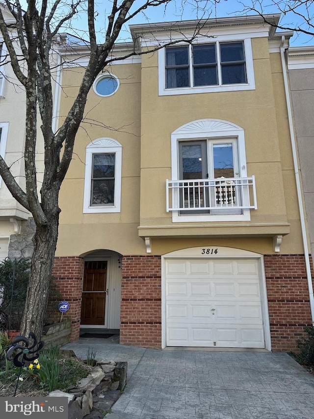 3814 Woodlawn Ct, Alexandria, VA 22304 - view of front of home with an attached garage, decorative driveway, stucco siding, and brick siding