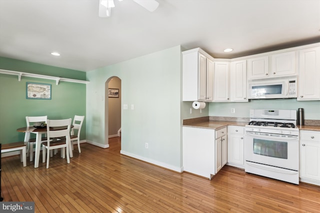 3814 Woodlawn Ct, Alexandria, VA 22304 - kitchen with white cabinets, white appliances, arched walkways, recessed lighting, and light wood-type flooring