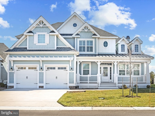 view of front of property with roof with shingles, an attached garage, driveway, a front lawn, and covered porch