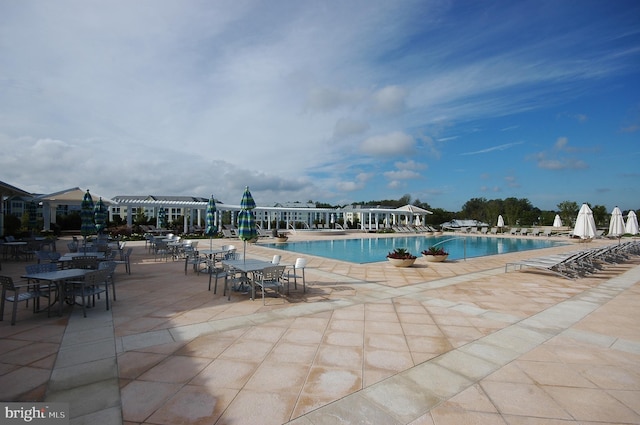 community pool with a pergola and a patio area