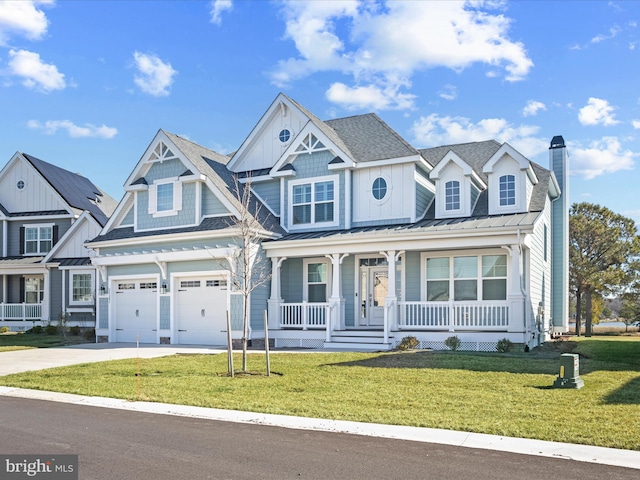 view of front of house with an attached garage, covered porch, concrete driveway, and a front yard