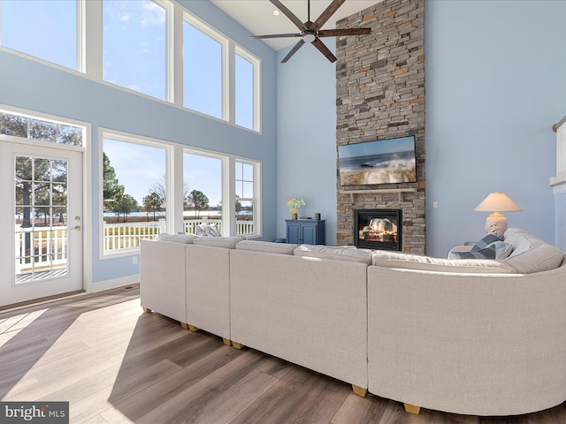 living room with ceiling fan, a fireplace, and wood finished floors