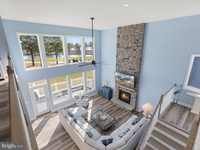 living room featuring a ceiling fan, a wealth of natural light, and wood finished floors