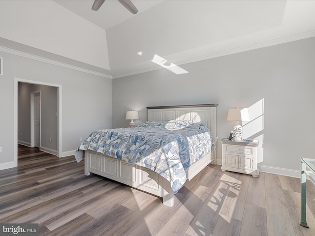 bedroom featuring a ceiling fan, crown molding, baseboards, and wood finished floors