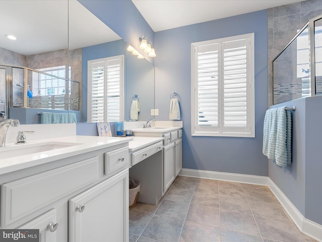 full bathroom featuring a shower stall, baseboards, plenty of natural light, and vanity