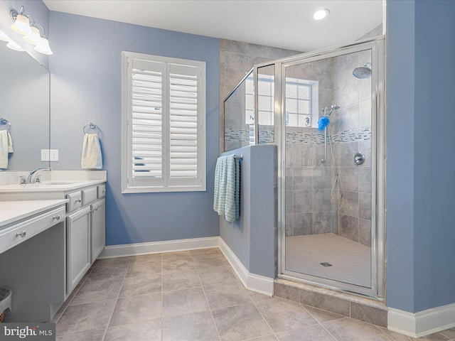 bathroom featuring a stall shower, baseboards, vanity, and tile patterned floors