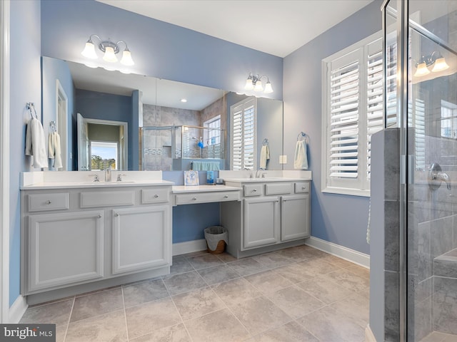 bathroom with a stall shower, baseboards, and vanity