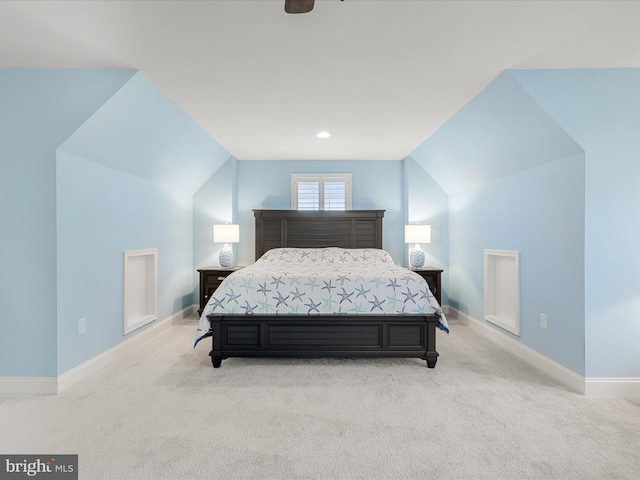 carpeted bedroom featuring baseboards and vaulted ceiling
