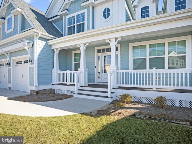 view of exterior entry featuring an attached garage, a porch, and roof with shingles