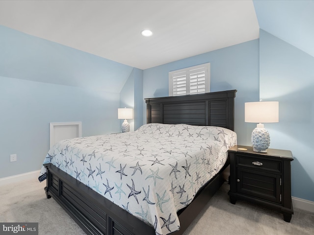 bedroom featuring baseboards, lofted ceiling, and light colored carpet