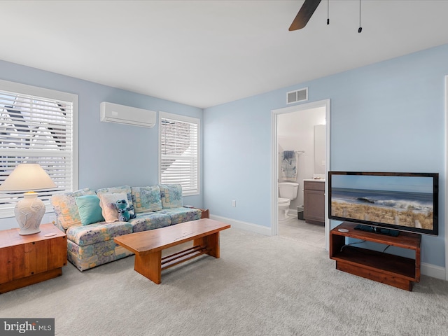 carpeted living area featuring a wall mounted air conditioner, baseboards, ceiling fan, and visible vents
