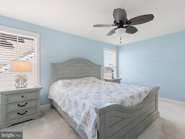 bedroom with light colored carpet, ceiling fan, and baseboards