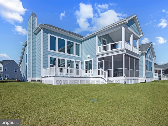 rear view of property with a balcony, a sunroom, a chimney, and a lawn