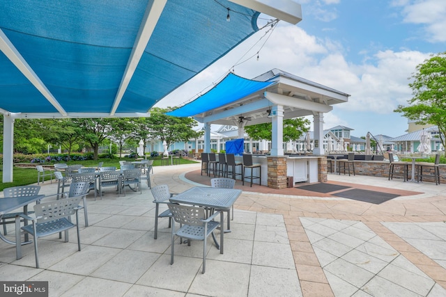 view of patio / terrace featuring a ceiling fan, outdoor dry bar, and a residential view