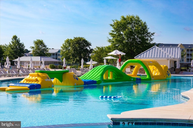 view of pool featuring a water play area, a water slide, and playground community