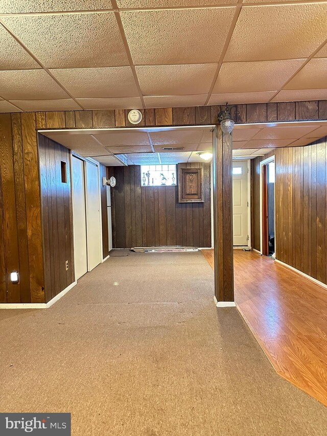 1224 Sheridan Ave, Baltimore, MD 21239 - basement with wooden walls, a drop ceiling, and baseboards