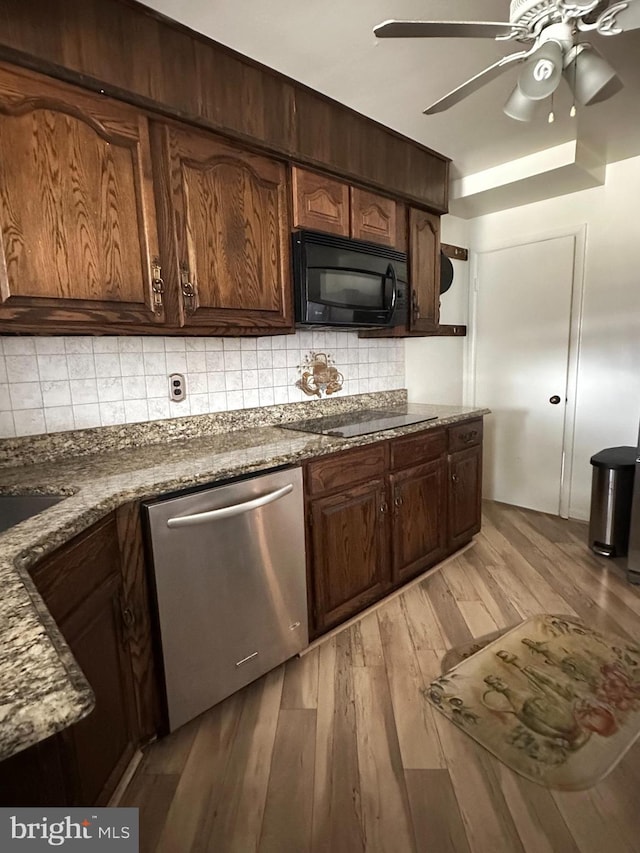 1224 Sheridan Ave, Baltimore, MD 21239 - kitchen with dark stone counters, decorative backsplash, black appliances, ceiling fan, and light wood-type flooring