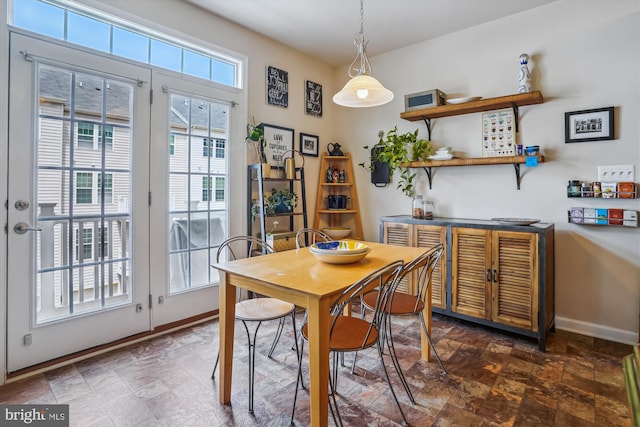 dining space featuring stone finish flooring and baseboards