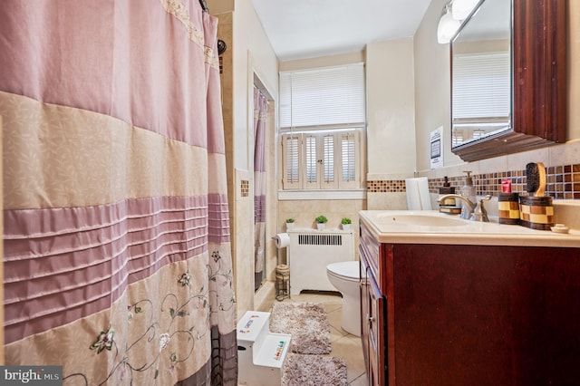 bathroom with toilet, radiator heating unit, tile patterned flooring, a shower with shower curtain, and vanity