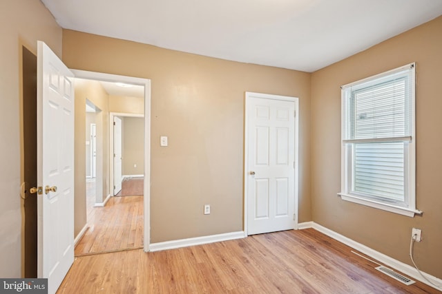 unfurnished bedroom with baseboards, visible vents, and light wood-style floors