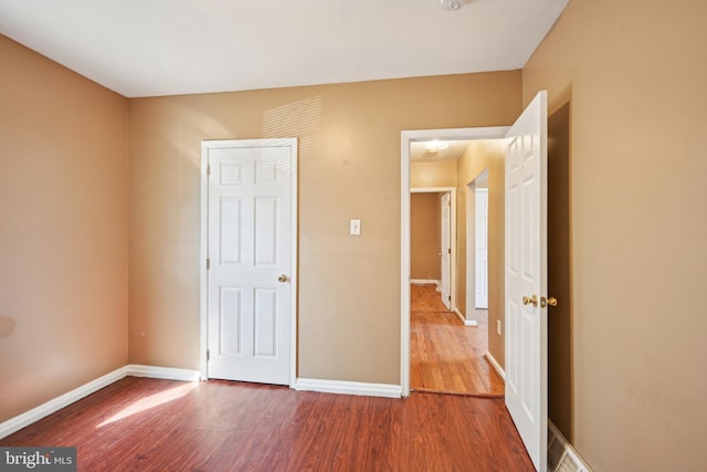 unfurnished bedroom with baseboards and wood finished floors
