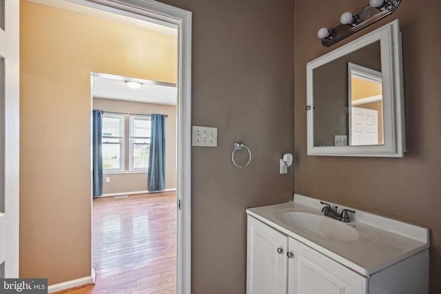 bathroom featuring baseboards, vanity, and hardwood / wood-style flooring