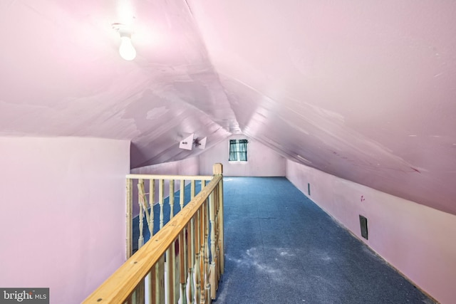 additional living space featuring carpet floors and vaulted ceiling