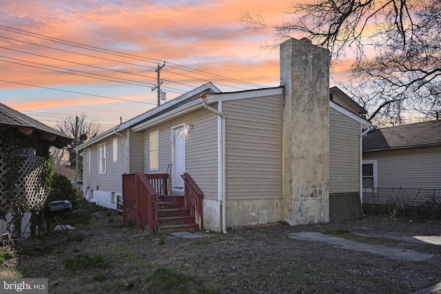 back of property at dusk featuring fence