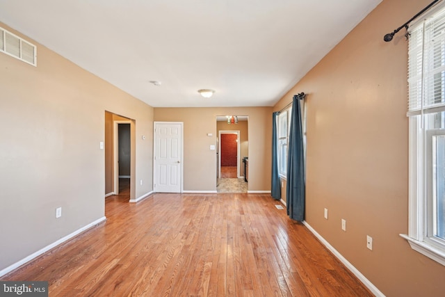 unfurnished room with light wood-style flooring, baseboards, and visible vents