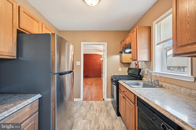 kitchen featuring light countertops, baseboards, under cabinet range hood, a sink, and black appliances