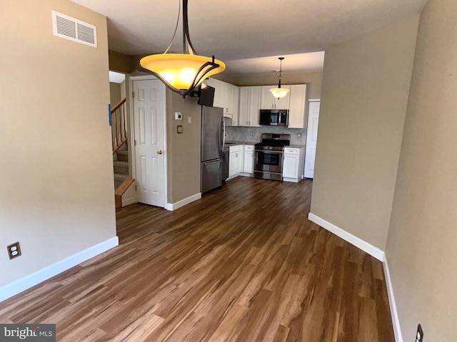 kitchen with visible vents, baseboards, dark wood-type flooring, white cabinets, and appliances with stainless steel finishes