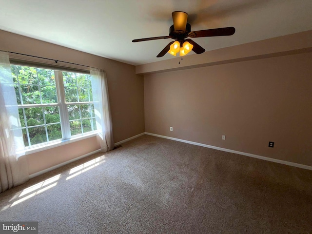 carpeted spare room with baseboards and ceiling fan