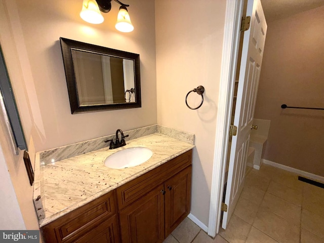 bathroom featuring tile patterned floors, baseboards, and vanity