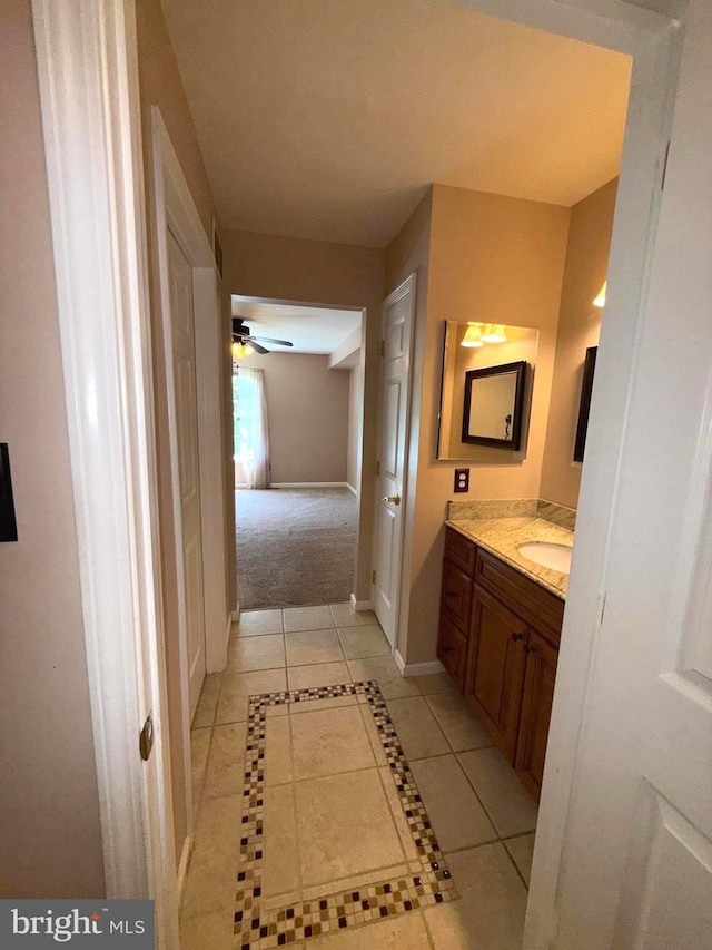bathroom featuring baseboards, ceiling fan, tile patterned floors, and vanity