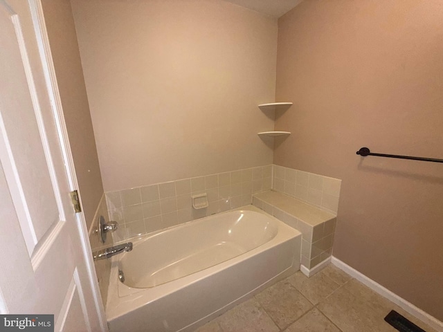 bathroom featuring baseboards, tile patterned flooring, and a garden tub