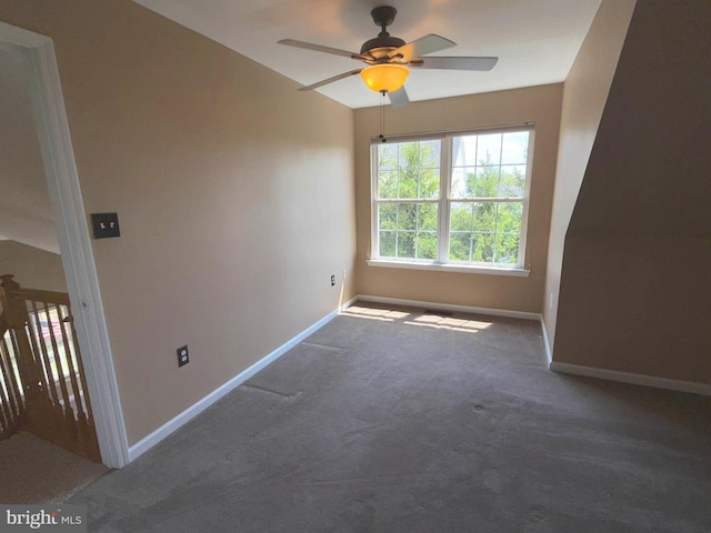 carpeted empty room featuring baseboards and a ceiling fan