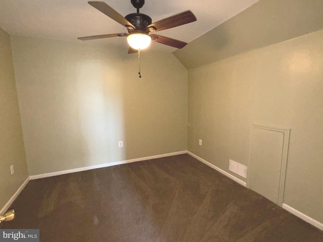 unfurnished room with baseboards, ceiling fan, dark carpet, and lofted ceiling