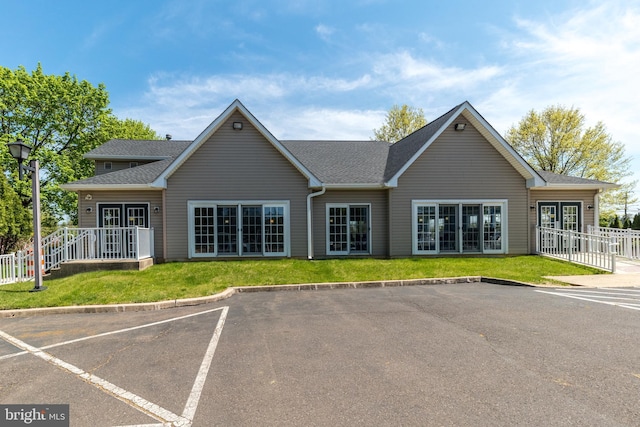 back of house with fence, a yard, uncovered parking, and french doors