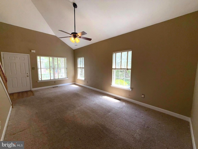 carpeted empty room featuring baseboards, a ceiling fan, and high vaulted ceiling