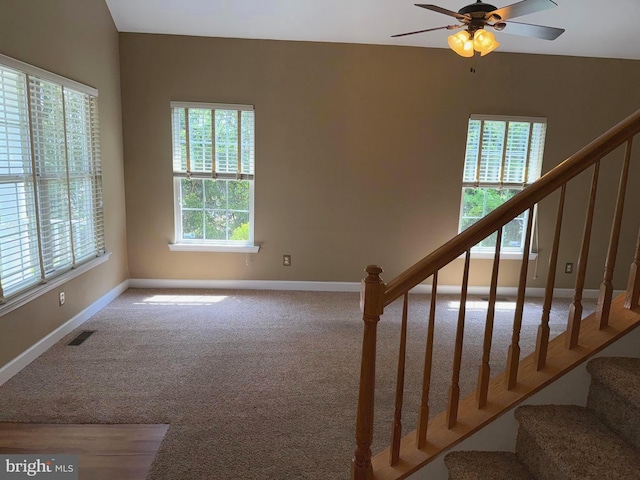 interior space featuring stairway, plenty of natural light, carpet flooring, and visible vents