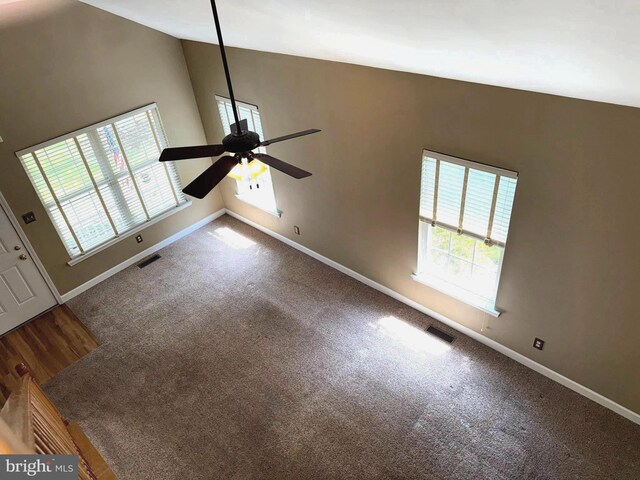 interior space with baseboards, a ceiling fan, and visible vents