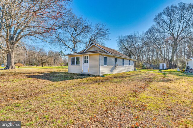 view of side of home with an outdoor structure and a yard