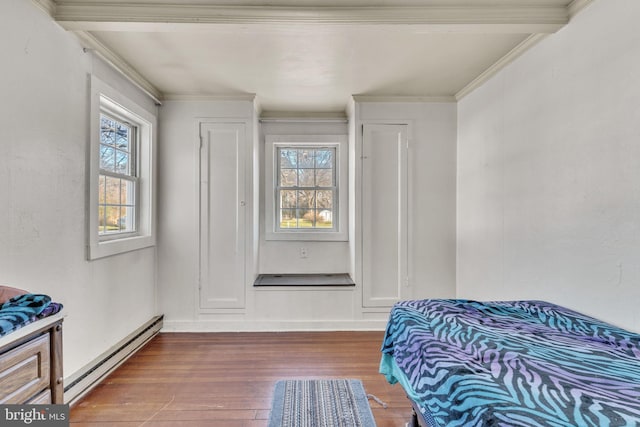 bedroom featuring baseboard heating, ornamental molding, and hardwood / wood-style floors